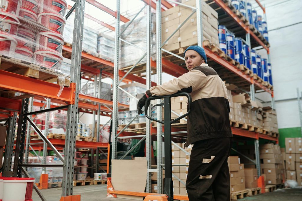 Ouvrier manipulant des cartons dans un entrepôt, illustration de la prévention des troubles musculo-squelettiques